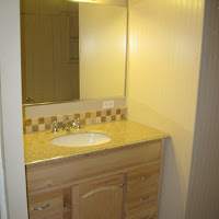 This is the new vanity that we installed along with a mirror, new lighting, tile backsplash and new electrical outlets. The flooring is new as well.