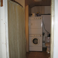 Doorway into the bathroom. With washer/dryer straight ahead and the water heater is just to the left of that. We built a small wall around the water heater as it was a bit of an eye sore. We also built a hidden door so the home owner could easily access the water heater (when needed).
